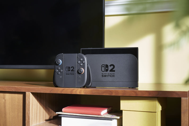 Nintendo Switch 2 console on a wooden surface with a television in the background